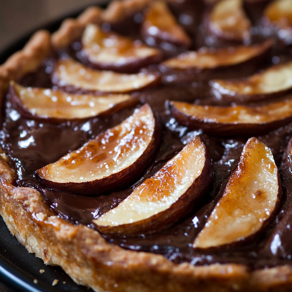 Gros plan de la Tarte aux Poires et Chocolat, montrant sa texture riche et ses saveurs.